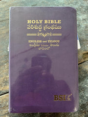 Purple Bible with English and Telugu text on a wooden surface